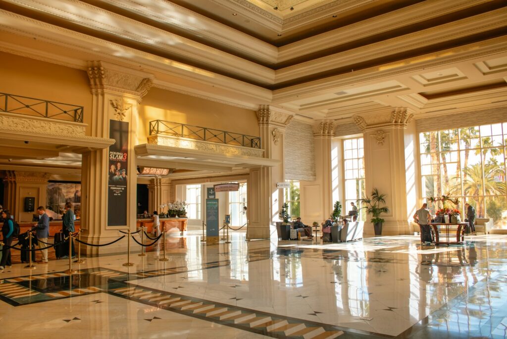 A grand sunlit hotel lobby, illustrating the lifestyle management side of household support
