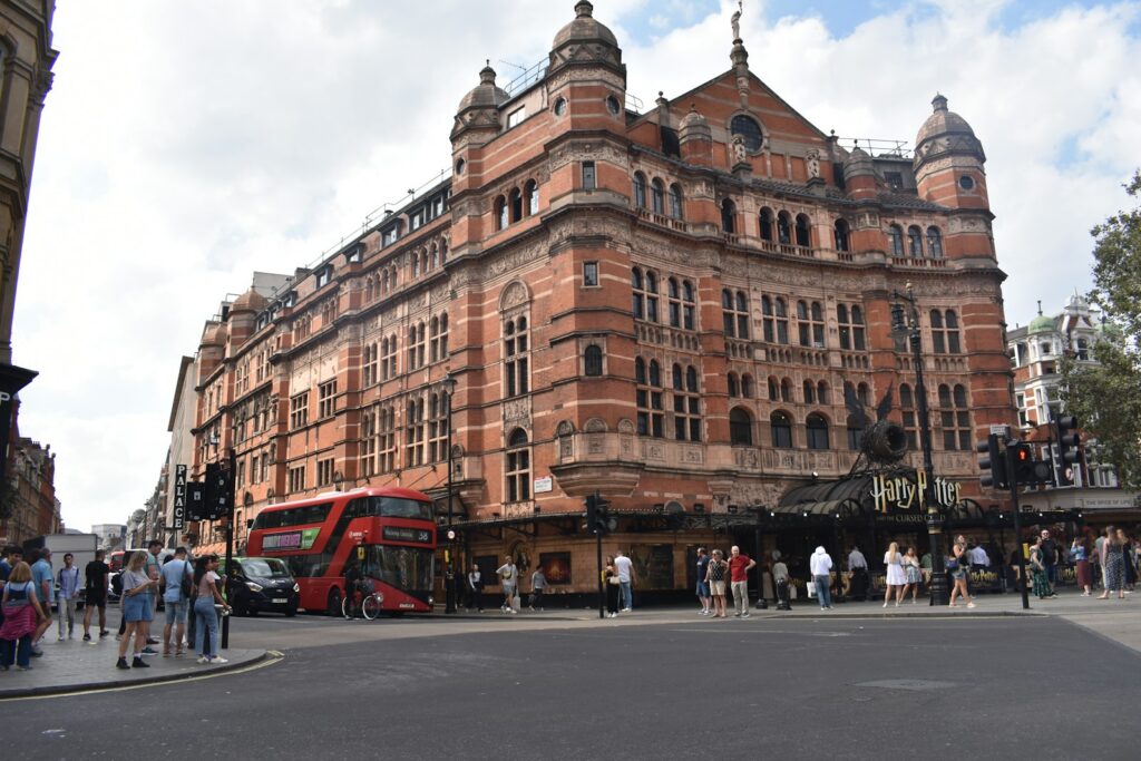 A red double-decker bus passing through London's West End, near Leicester Square