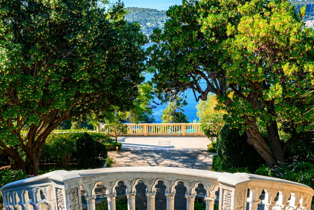 A stone balustrade on a villa terrace overlooking a bay, representing the lifestyle side a concierge manages alongside a family office