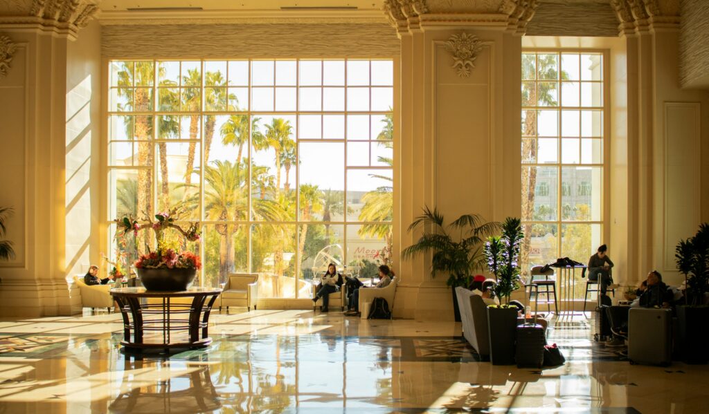 How to choose a luxury concierge — a sunlit marble hotel lobby with tall windows and palms