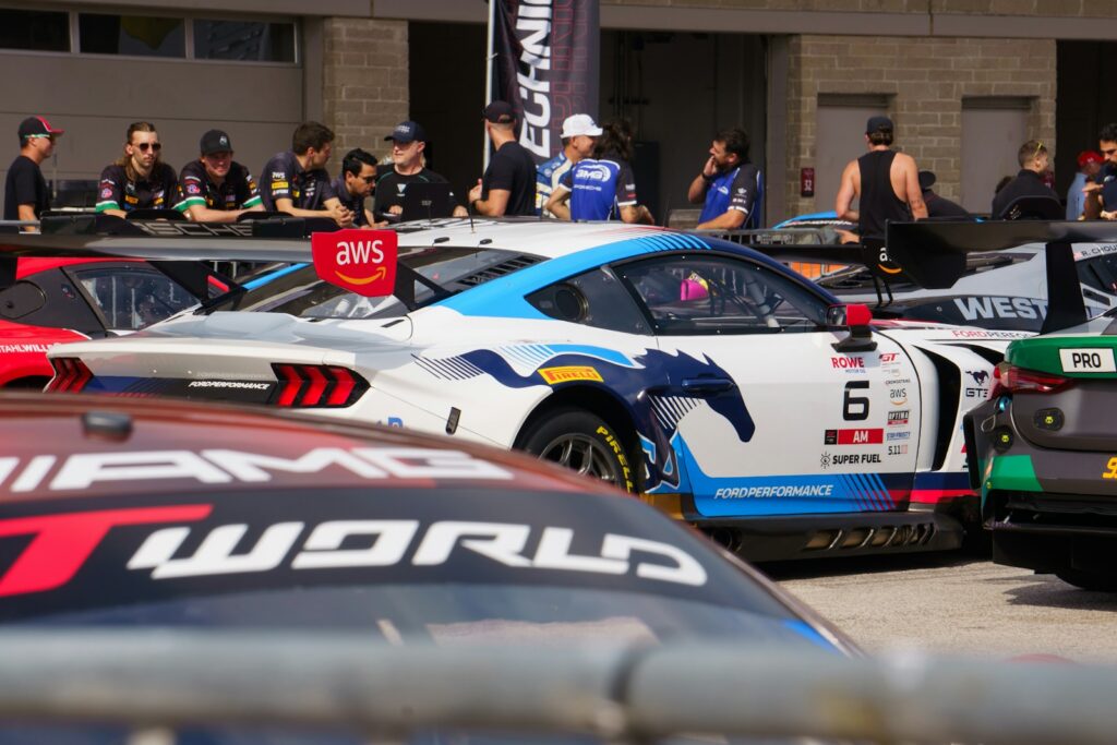 GT race cars lined up in the pit lane before an endurance race