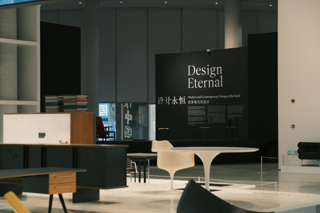 Furniture and objects displayed against gallery walls at a design exhibition