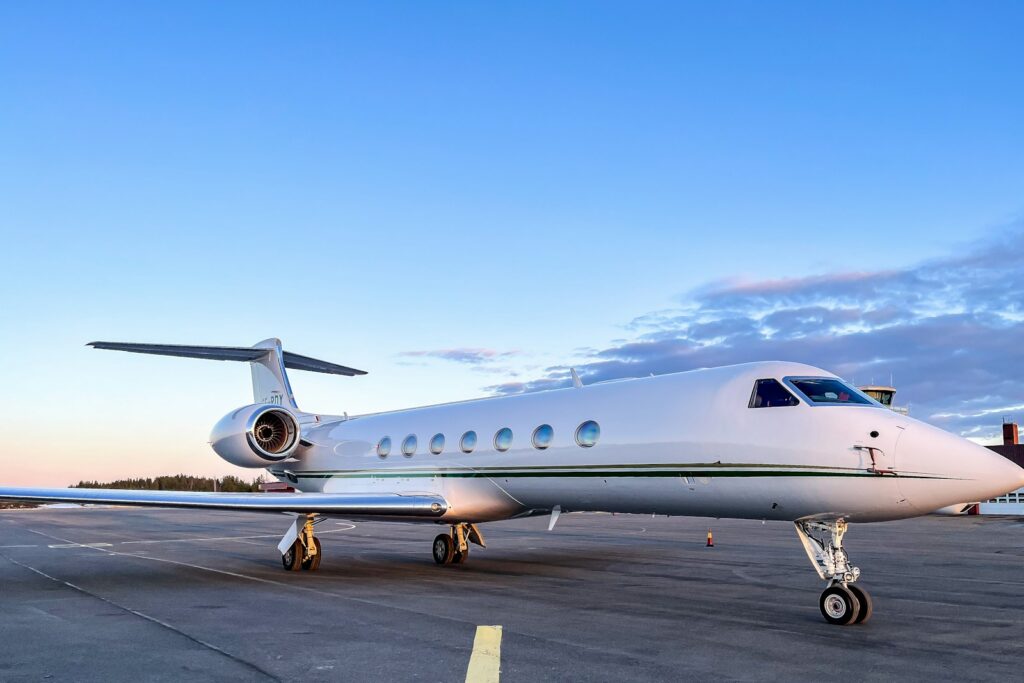 A private business jet parked on the tarmac at an airport apron