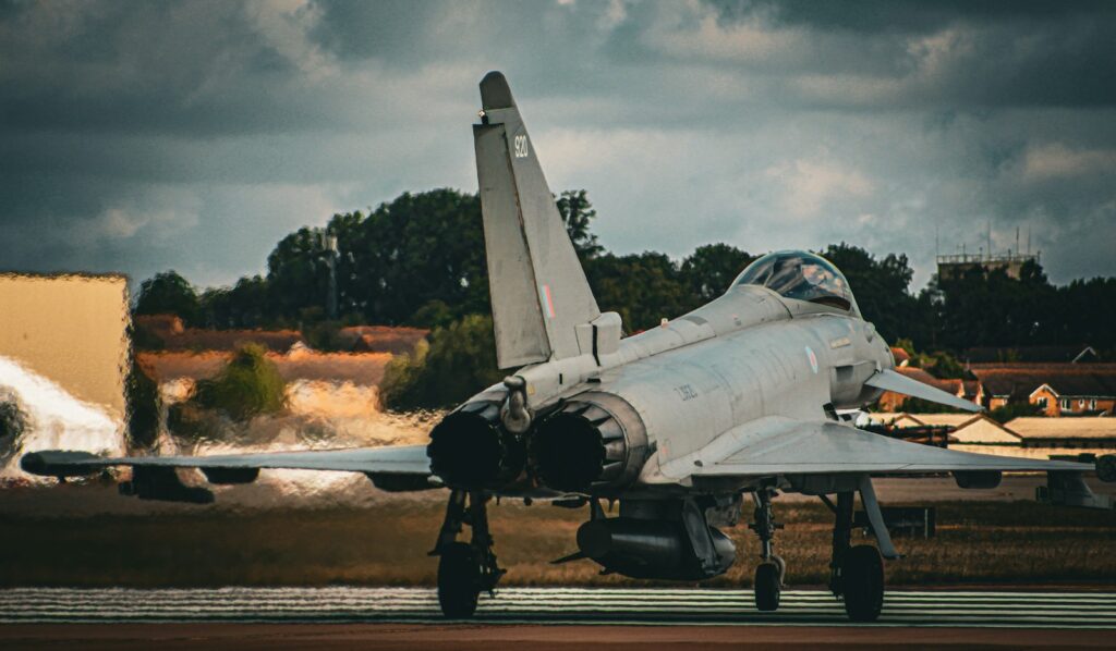 A fighter jet on static display on the apron under a dramatic sky at an air show