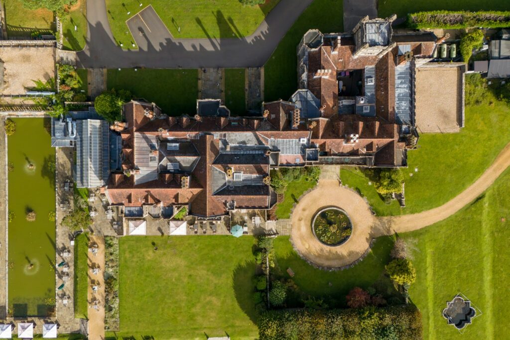 An aerial view of a historic estate and its formal gardens, held across generations