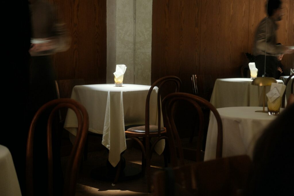 A quiet fine-dining room laid for service, reflecting the shift in luxury spending from goods to experiences