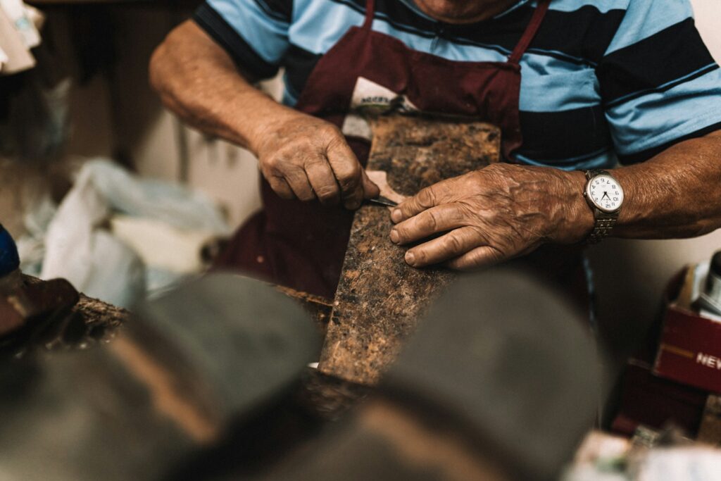 Craftsman working leather by hand in a Florentine workshop