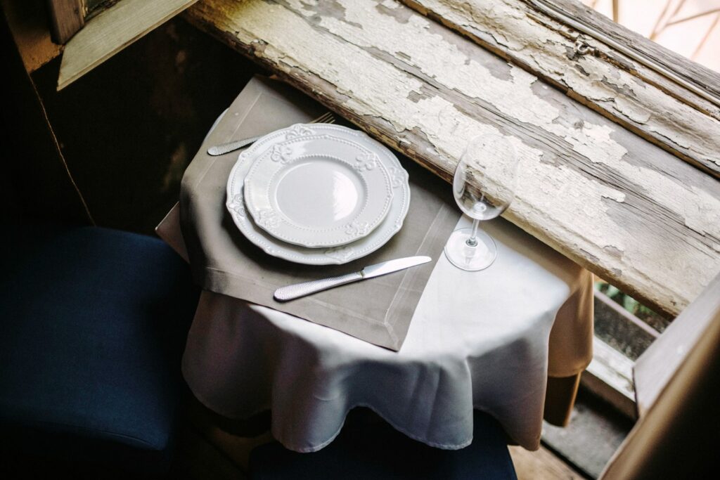 A single table set by a window, the quiet register Geneva’s dining rooms are built around