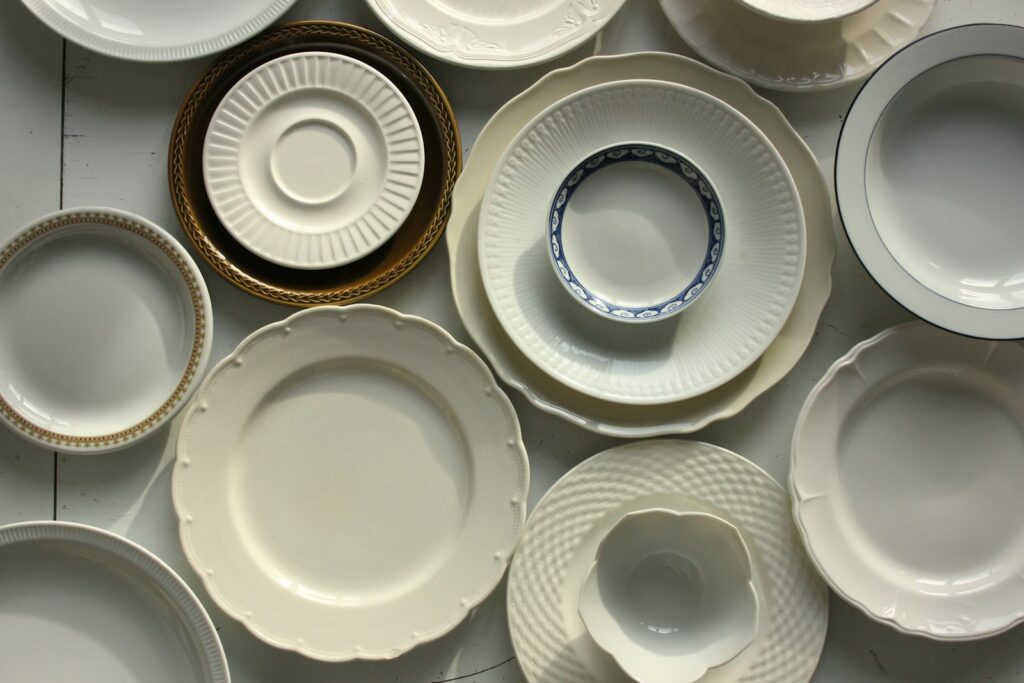 Plain white service plates stacked before service, which is close to what Geneva rewards: technique without commentary