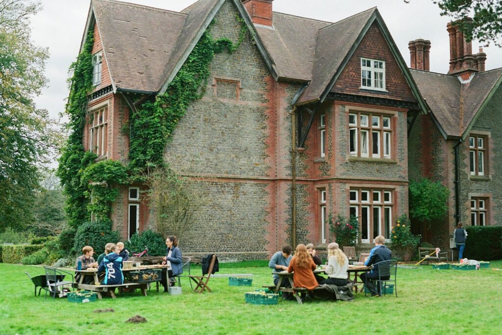 Audience picnicking at tables in the garden during the long interval at Glyndebourne