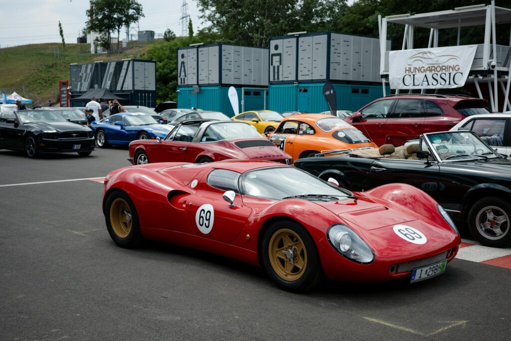 Classic racing cars parked in the paddock at a historic motorsport meeting