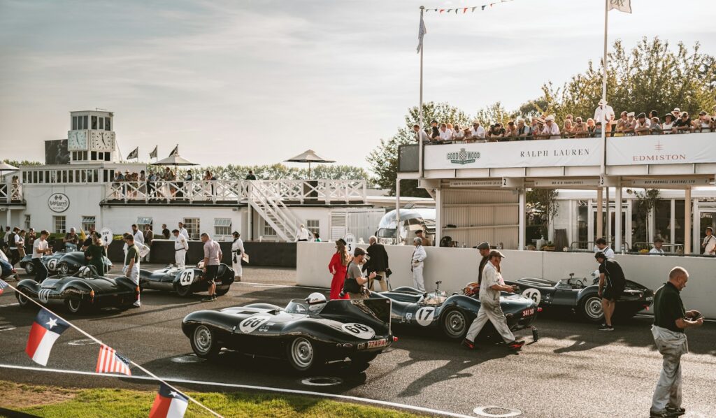 Historic racing cars in the pit lane at the Goodwood Members Meeting