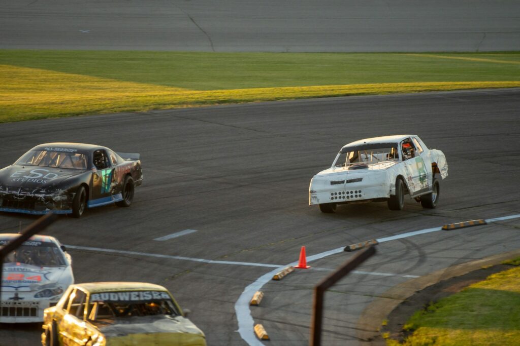 Two vintage saloon cars racing side by side on a circuit