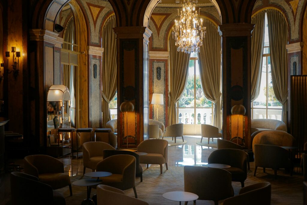 A quiet hotel lounge with armchairs and a chandelier, the kind of setting where a concierge relationship is discussed