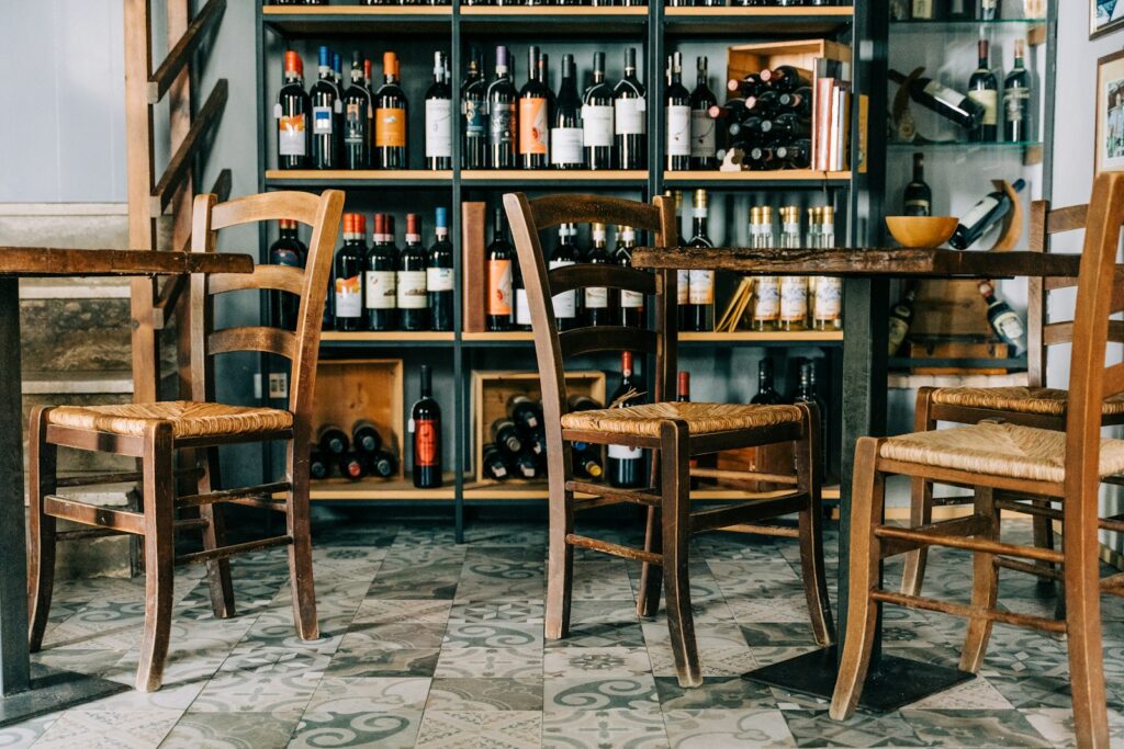 A trattoria interior with the wine shelved along the wall, the register Milan has never abandoned