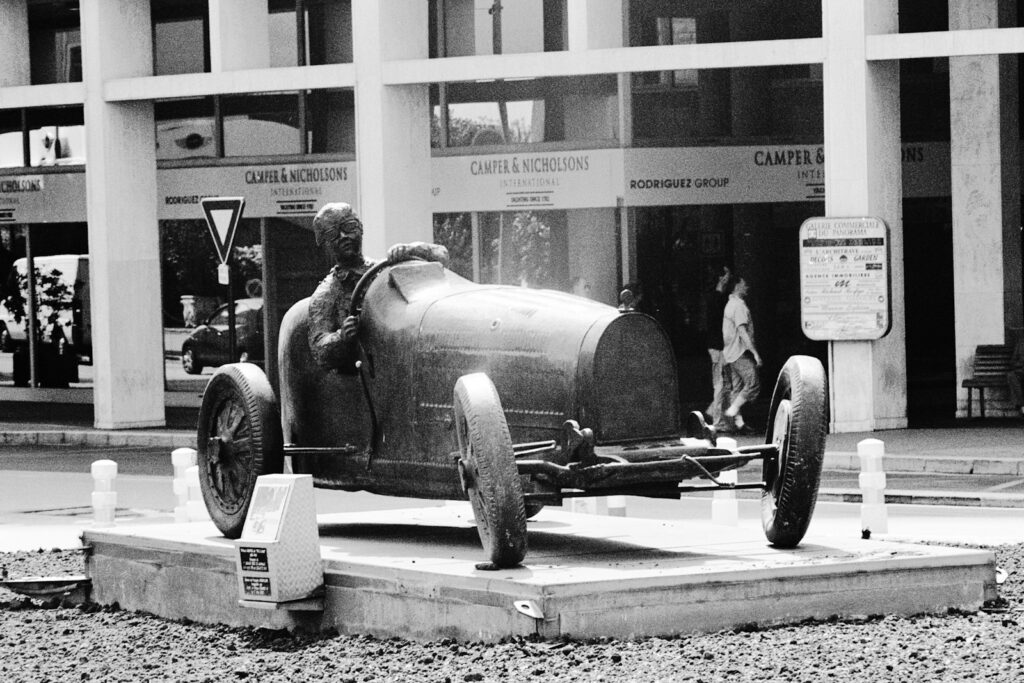 Vintage period race car parked in front of a building in Monaco