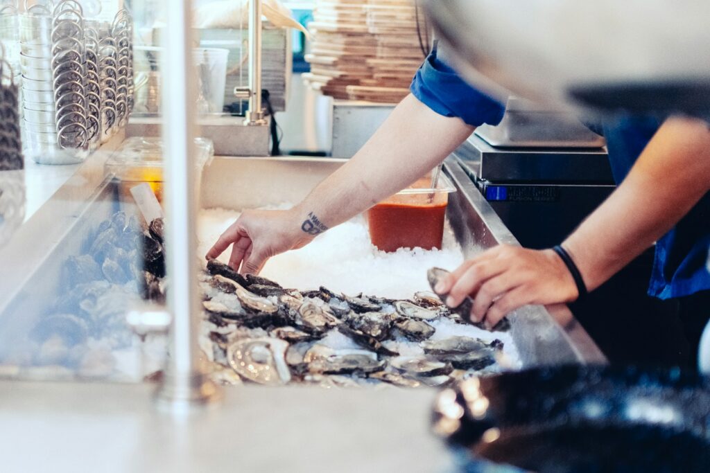 A shucking counter in action, where the handful of stools in front of it are the hardest seats in the room to get