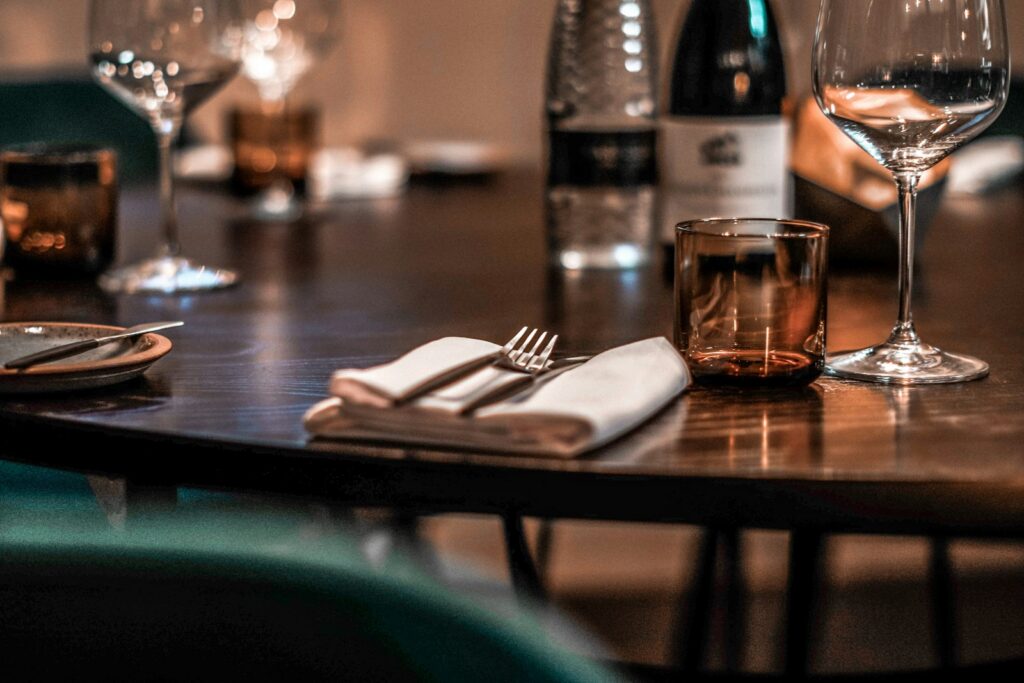 A table set apart from its neighbours, which matters more to the evening than candlelight does
