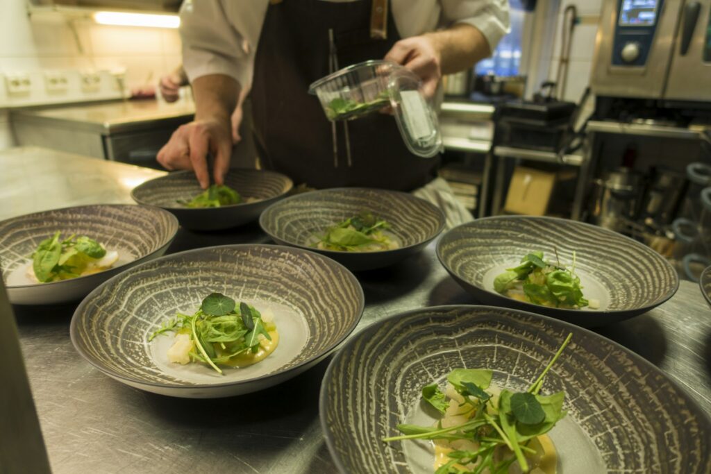A kitchen plating a plant-based tasting menu, where vegetables are the technique rather than the substitution