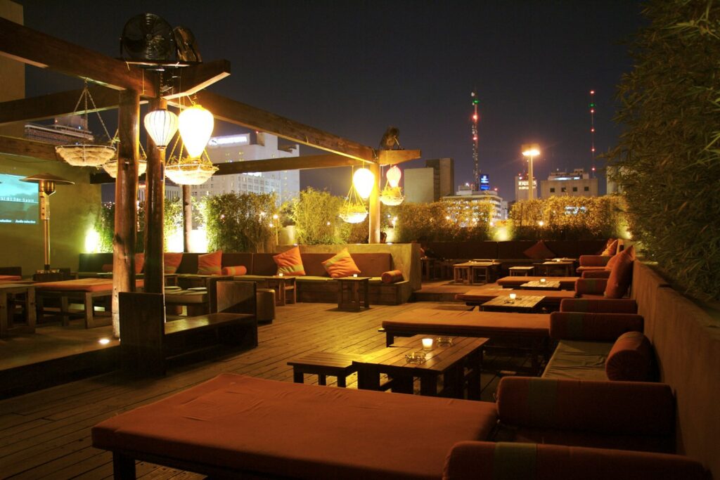 A rooftop lounge laid out for the evening, the setting that separates a dining room from a lounge