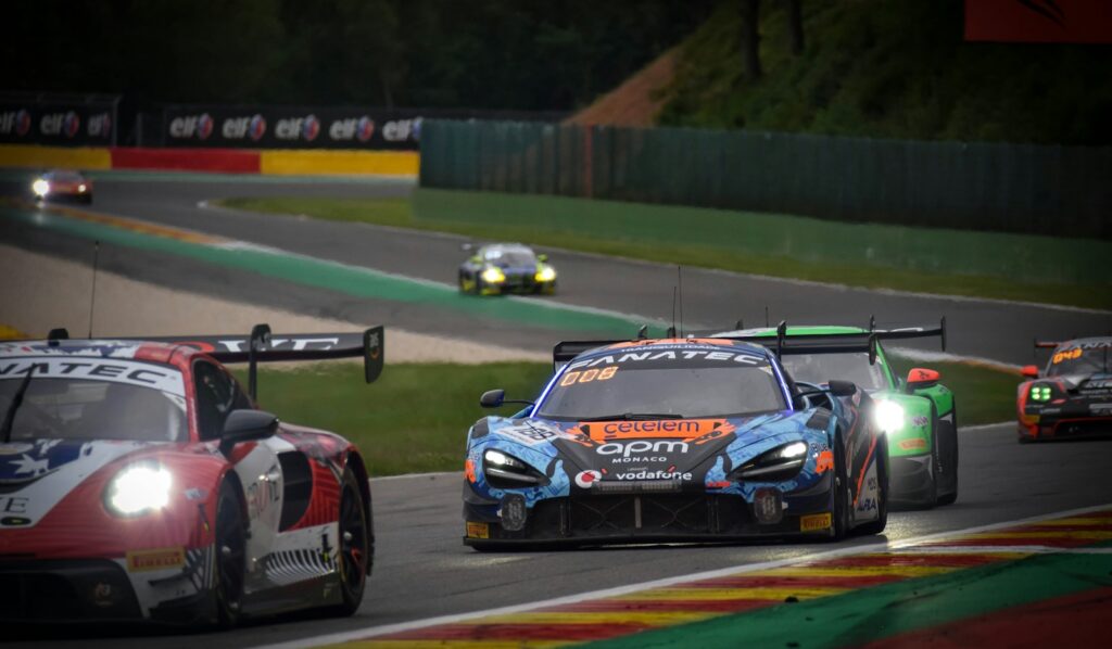 GT cars racing through Eau Rouge at dusk during the 24 Hours of Spa
