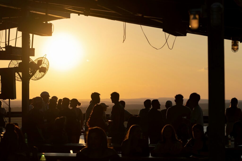A crowd gathered outdoors at sunset in Austin during festival season