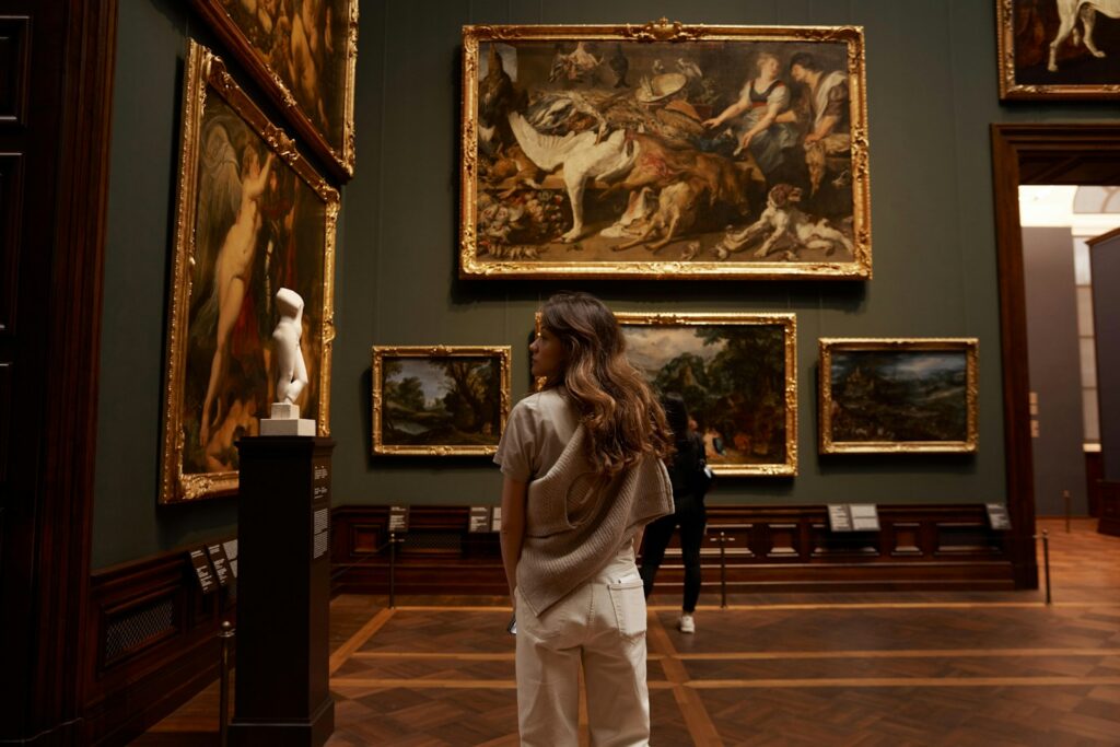Visitor examining Old Master paintings and sculpture on a gallery stand