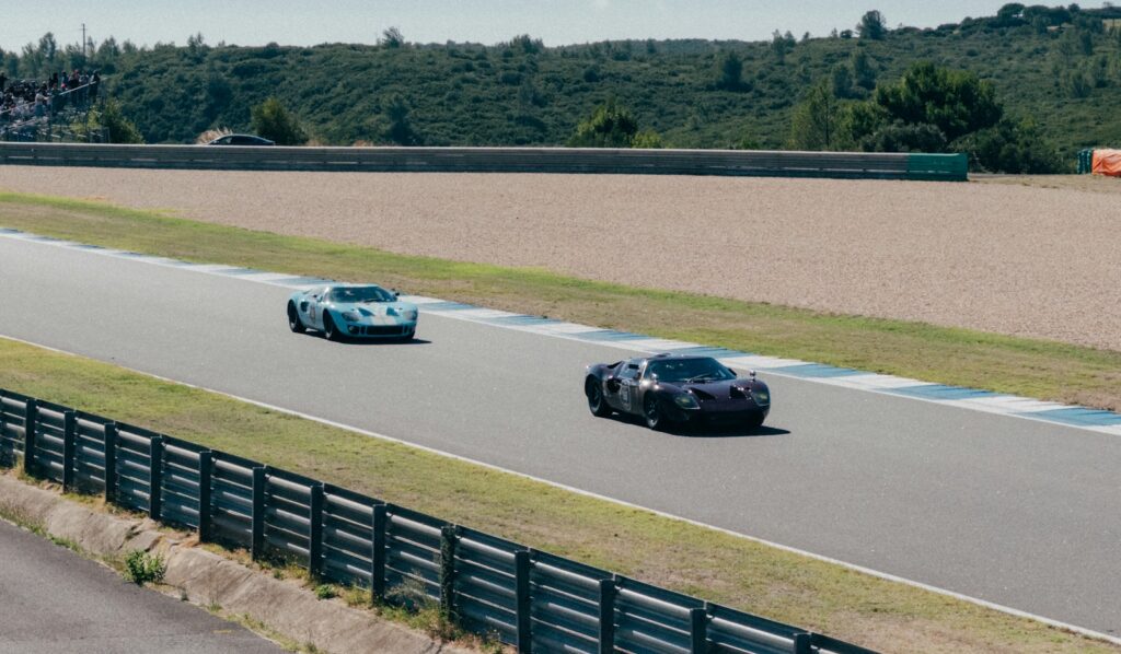 Vintage Ford GT40s racing wheel-to-wheel on track at Le Mans Classic