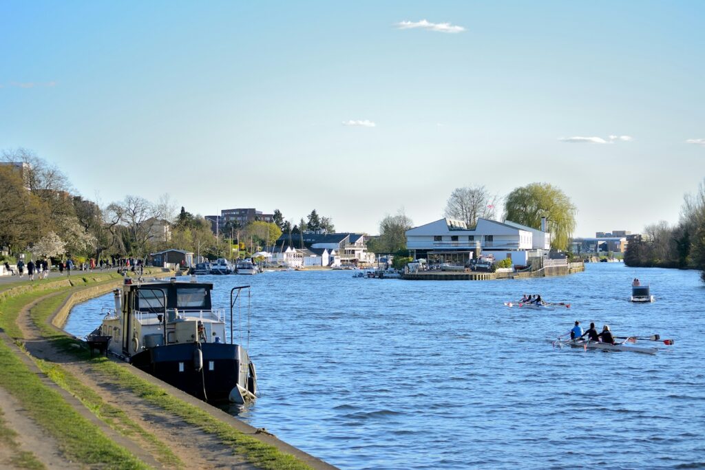 Rowing boats on the Thames beside a riverside towpath
