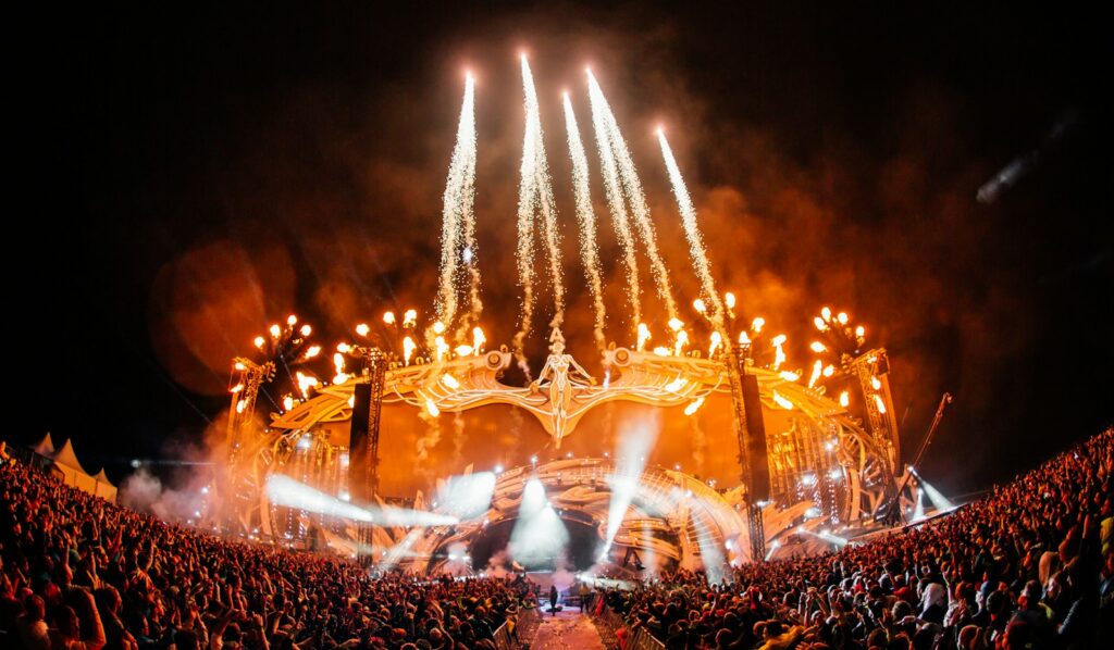 Illuminated festival mainstage with fireworks display at night