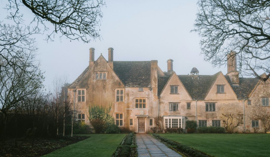 Family office definition — a stone manor house at the end of a long drive on a misty morning