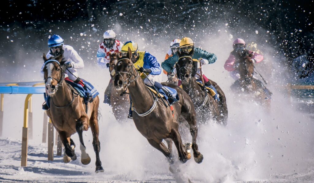 Jockeys racing thoroughbreds across the frozen lake at White Turf St Moritz