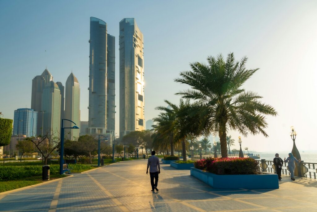 Palm-lined promenade on the Abu Dhabi Corniche with the city towers rising behind
