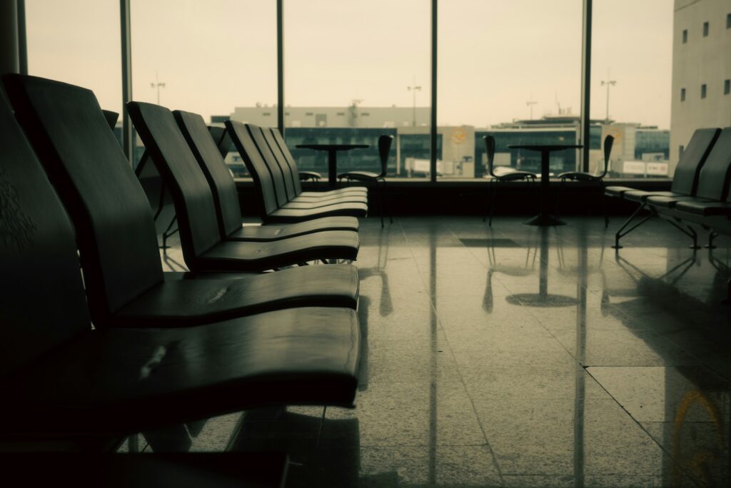 Quiet airport lounge with empty seats and terminal windows in soft evening light