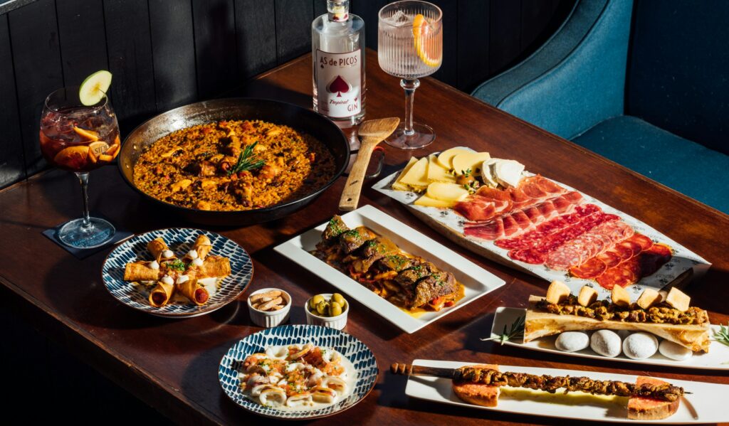 Paella, cured ham and tapas laid out on a table at one of the best restaurants in Barcelona