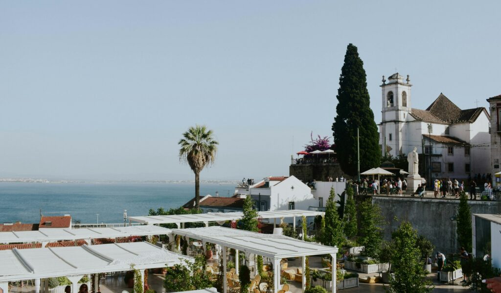Terrace tables above Alfama with the Tagus beyond, a setting for the best restaurants in Lisbon