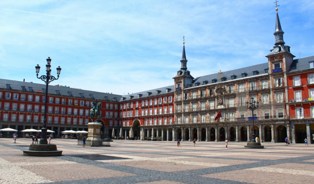 Plaza Mayor in Madrid, with café terraces beneath its red facades, in the setting of the best restaurants in Madrid