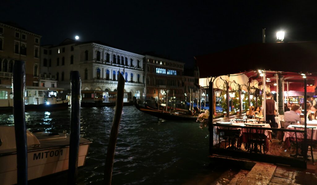 Candlelit canal-side terrace at night at one of the best restaurants in Venice