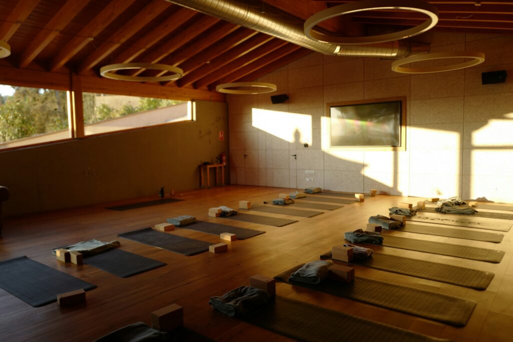 Sunlit studio with yoga mats and blocks laid out on a wooden floor
