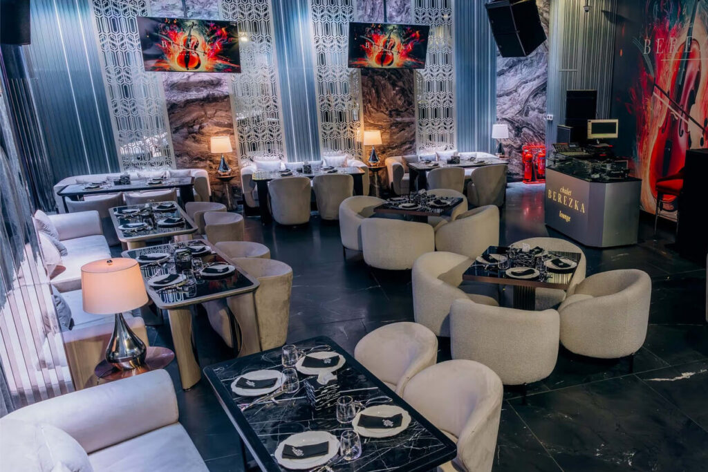 Indoor lounge at Chalet Berezka Dubai with marble tables and cream armchairs
