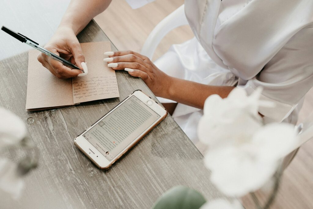 Making notes in a diary with a phone close at hand