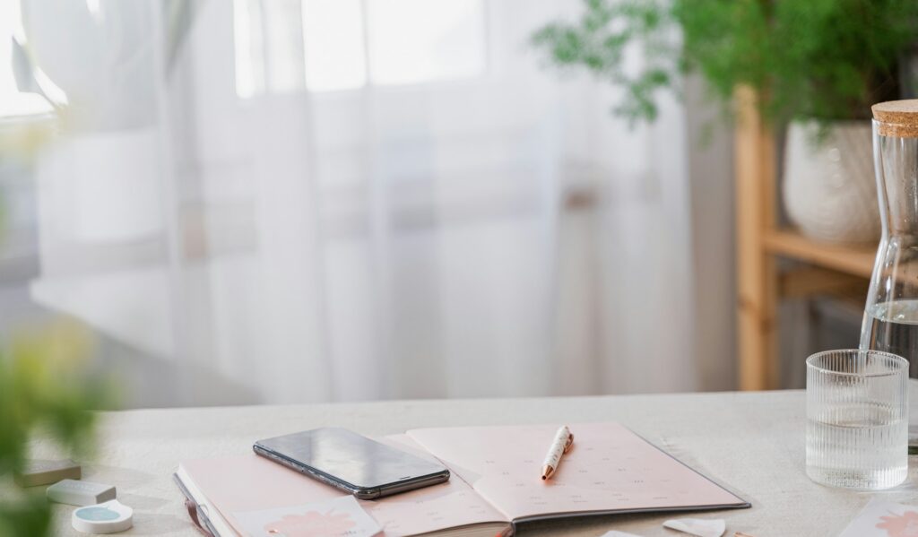 Luxury concierge tips — phone and open planner on a desk in soft daylight