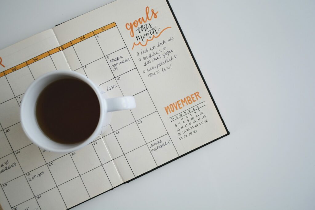 Monthly planner and a cup of coffee on a desk
