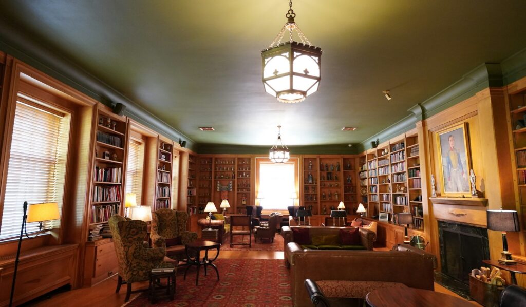Concierge vs private members club — a quiet club library with leather armchairs