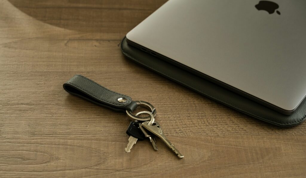 Concierge vs lifestyle manager — house keys and a laptop on a calm wood desk