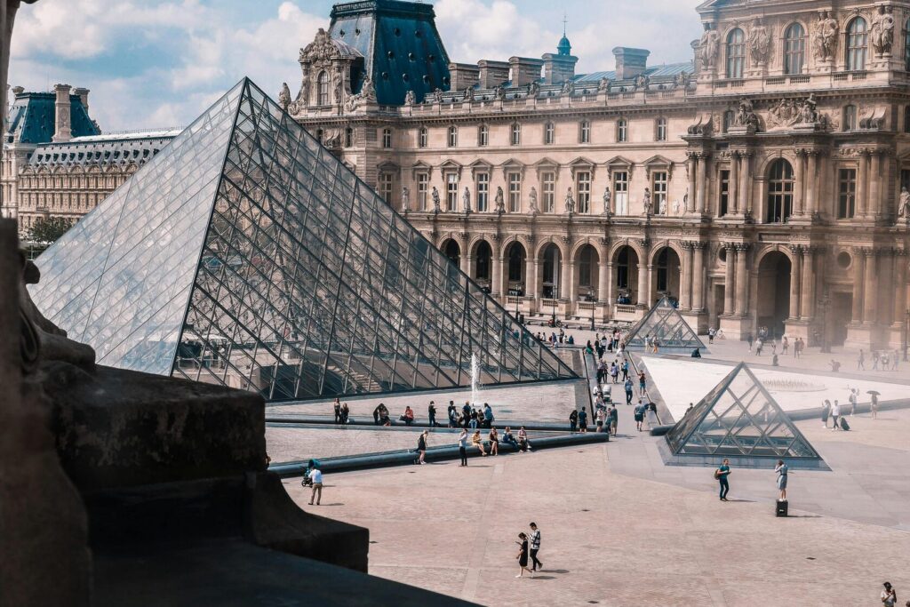 Glass pyramid and palace courtyard of the Louvre in Paris seen from a museum window