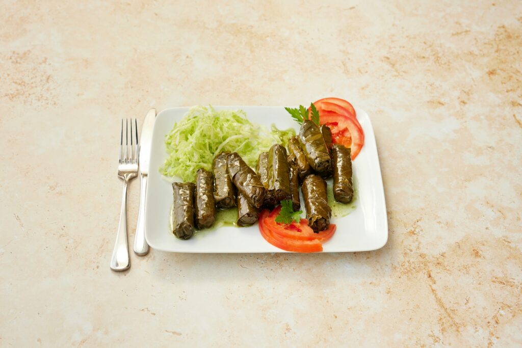 Dolmades, vine leaves stuffed with rice and herbs, served with tomato