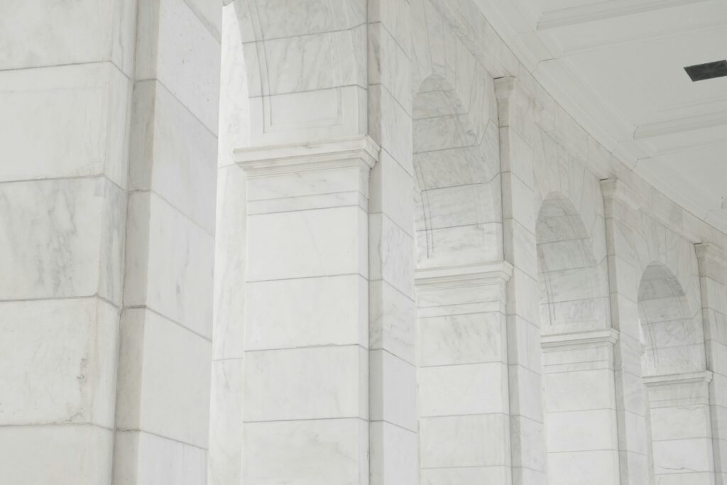 White marble columns with arched openings in a Cyclades-style interior