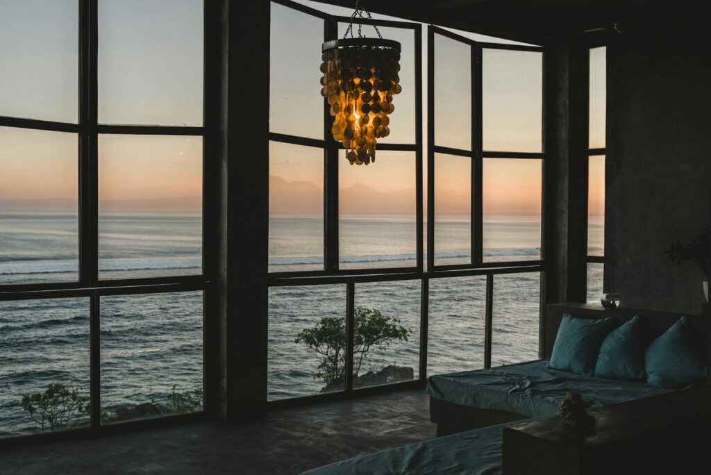 Living room with floor-to-ceiling windows overlooking the sea at dusk