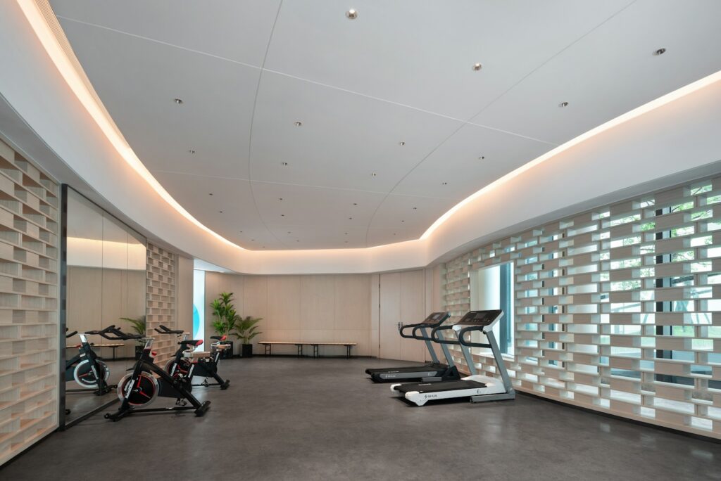 Quiet fitness assessment room with treadmills, studio bikes, and a latticed window wall